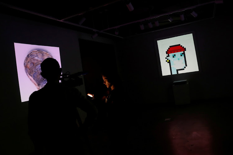 A television crew is seen next to the non-fungible token "CryptoPunk #7523", a series of 10,000 unique pixel-art characters made by Larva Labs in 2017 in New York City, US, in this June 4 2021 file photo. Picture: REUTERS/SHANNON STAPLETON