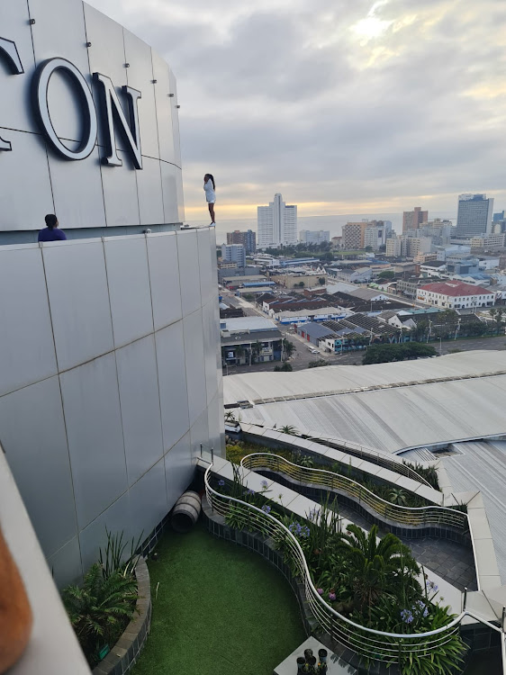 An unidentified woman stood on the edge of the 19-storey high iconic Hilton Hotel in Durban on Friday morning after what is understood to have been an emotional meltdown.