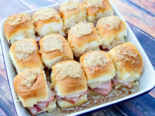 12 ham and Swiss sandwiches in a baking dish.