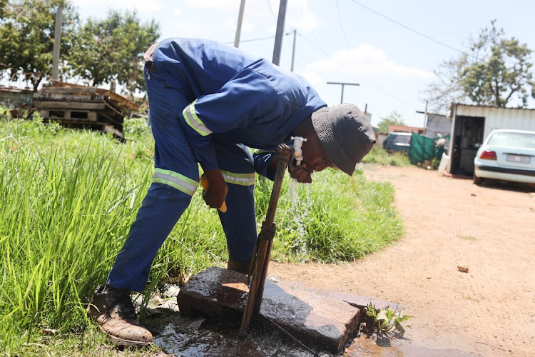 Msaba Mayihambe drinks water from a tap in Emandleni.