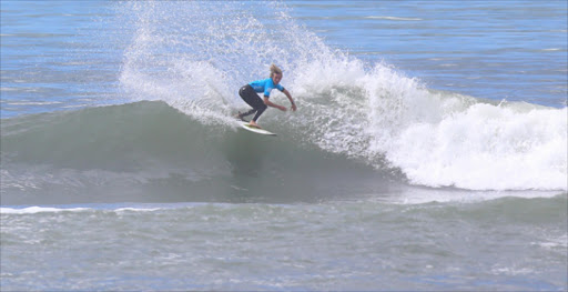 TAIL DANCE: After impressing the judges with a full backside carve, a competitor hangs by the fins before taking the drop on a glassy Nahoon Reef set wave yesterday Picture: SIBONGILE NGALWA