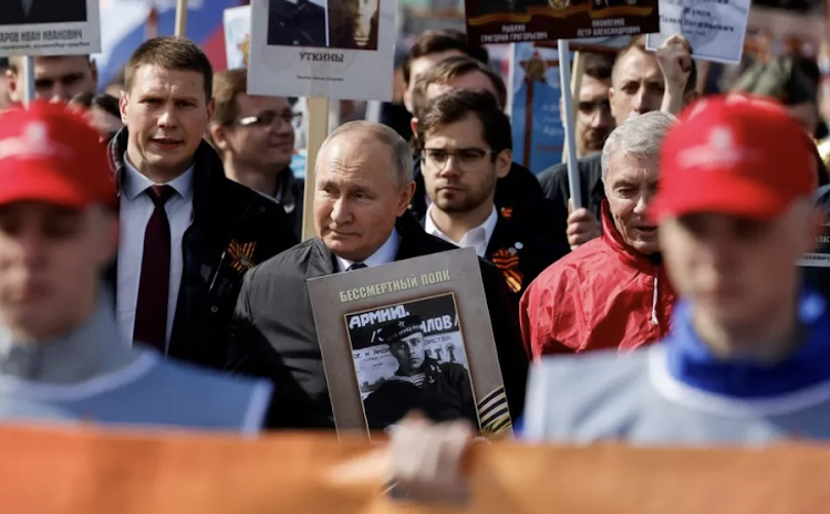 President Putin carrying a photograph of his father during last year's Victory Day celebrations