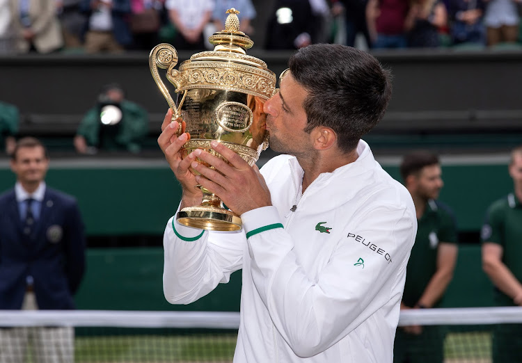 Serbia's Novak Djokovic kisses the trophy as he celebrates after winning his final match against Italy's Matteo Berrettini.