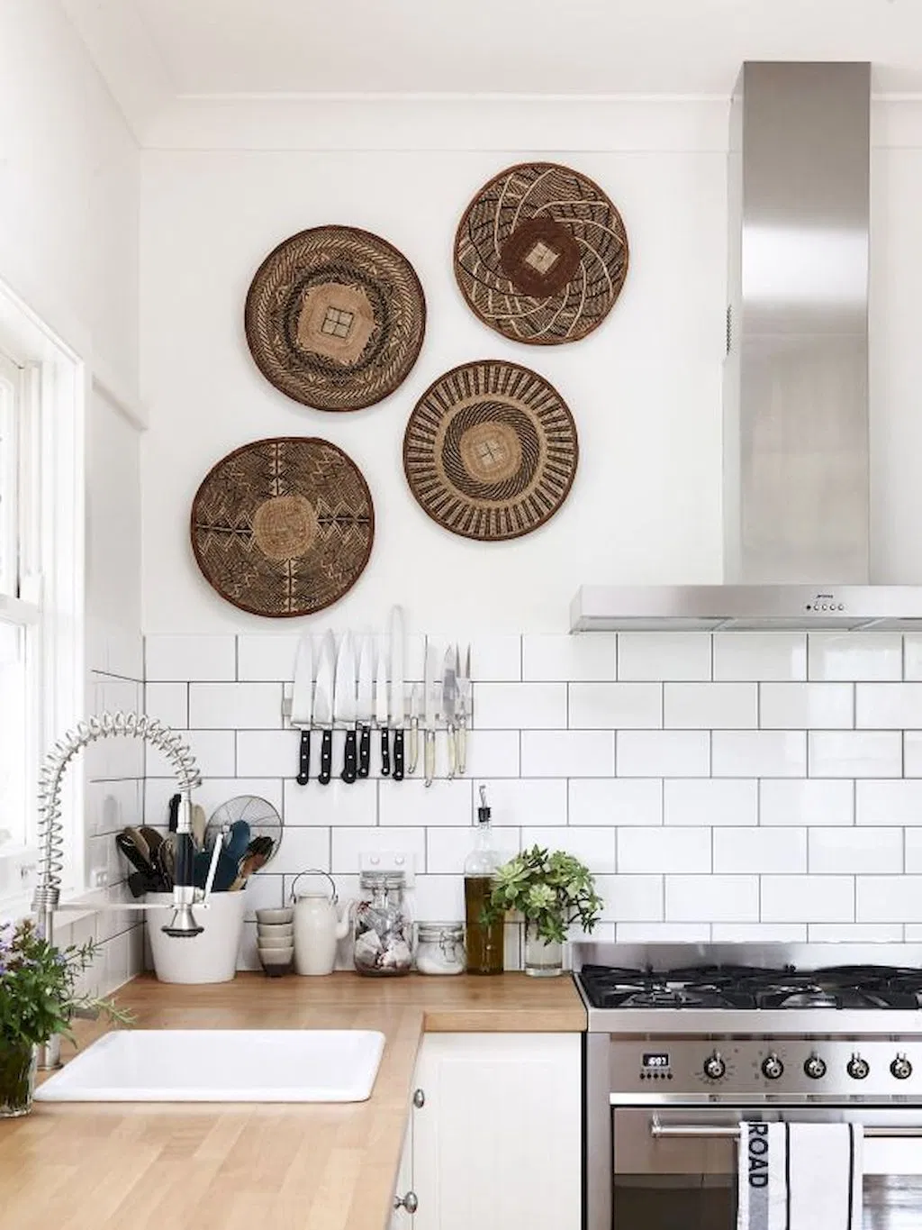 boho minimalist kitchen with woven wall decor, white subway tile backsplash and wood countertops