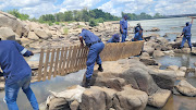 Border police dismantle homemade wooden bridges used for illegal crossings between South Africa and Zimbabwe.