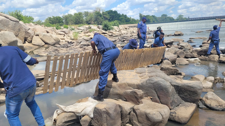 Border police dismantle homemade wooden bridges used for illegal crossings between South Africa and Zimbabwe.