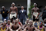 US ambassador Reuben E Brigety II shouts 'amandla' as he is welcomed by a traditional dance group during his visit at University of KwaZulu-Natal, Edgewood Campus, in Durban.