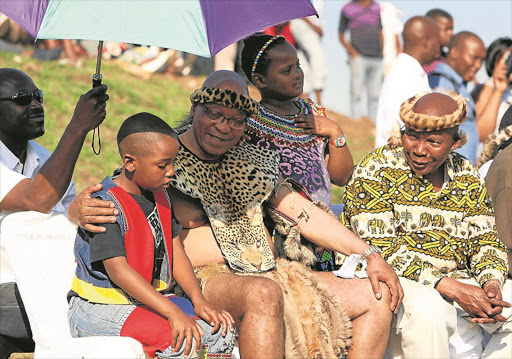 President Jacob Zuma with his children Snqumo and Thandisile during the wedding of his eldest son, Edward, at the family homestead in Nkandla at the weekend. The president's brother Mike Zuma is seated on the right.