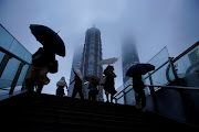 People hold umbrellas amid rainfall as Typhoon Chanthu approaches, in Shanghai, China September 13, 2021. 