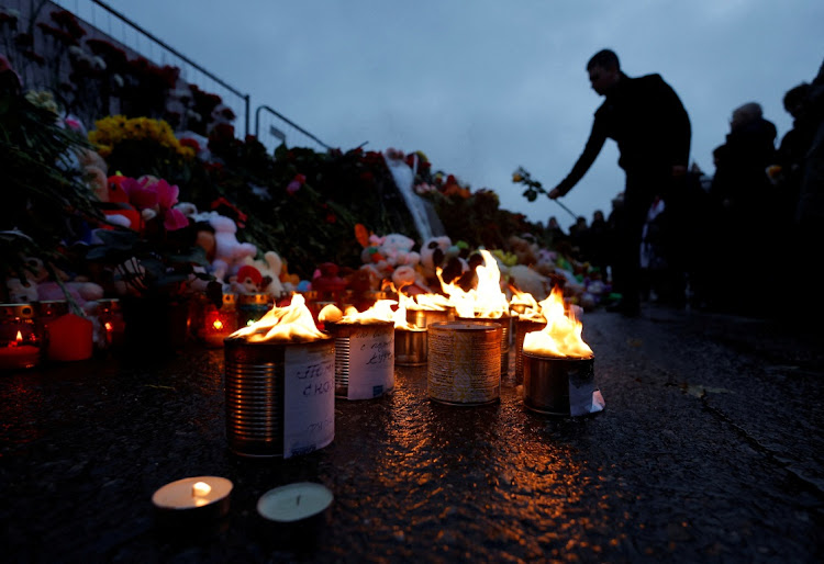 A man lays flowers at a makeshift memorial to the victims of a shooting attack, set up outside the Crocus City Hall concert venue in the Moscow Region, Russia on March 23 2024. Picture: REUTERS/Maxim Shemetov