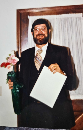 Bob Warmann holding AIE’s first contract, circa in 1980s 