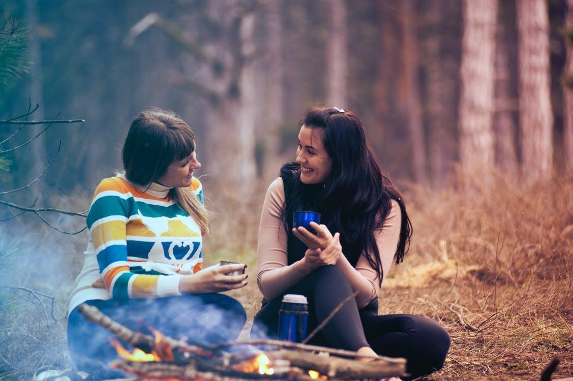 Free Two Women Sitting on Ground Near Bonfire Stock Photo