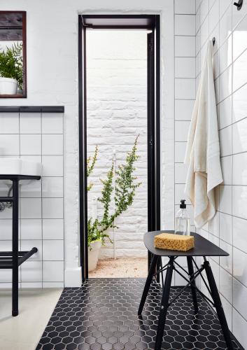 The main en-suite bathroom combines sleek modern fittings with a traditional iron ball-and-claw bath. Christo designed the steel plinths for the basins. The Eames-style stool makes a handy repository for shower accessories. The long narrow window leading to an outside courtyard is one of Nico’s favourite features: it creates the sensation of an outdoor shower without making it necessary to step outside.