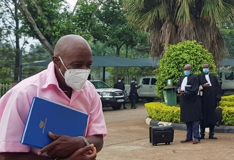 Paul Rusesabagina, portrayed as a hero in a Hollywood movie about Rwanda's 1994 genocide, walks in handcuffs to a courtroom in Kigali, Rwanda February 17, 2021.