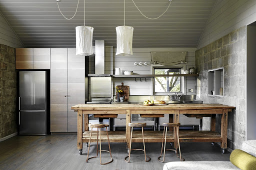 The kitchen area is a combination of warm wood, painted timber and metal. Wheels were added to the antique European work bench to give it height.