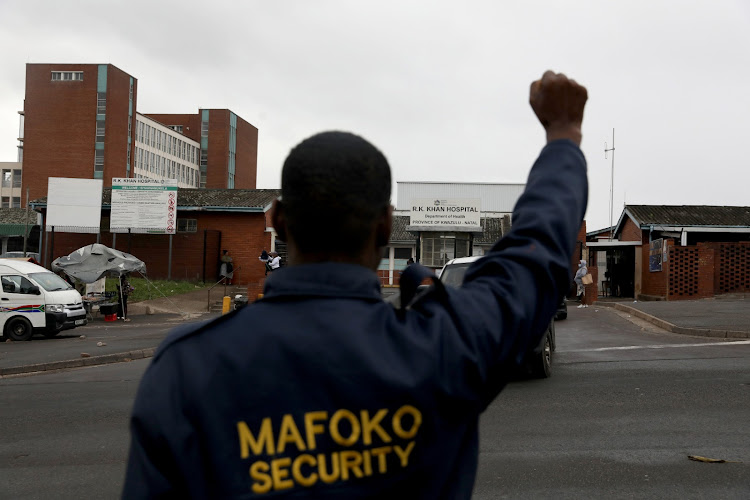 A member of Mafoko Security stands outside RK Khan hospital in Chatsworth protesting over payment issues.