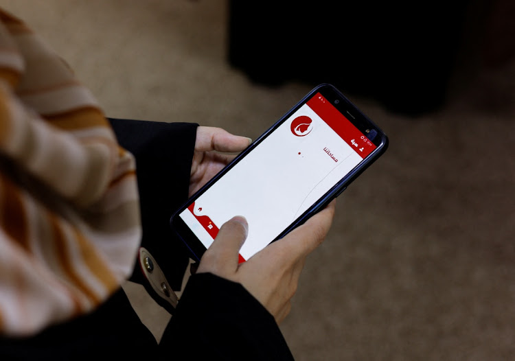 A Palestinian woman uses a Phone app that allows Gaza women to report domestic abuse anonymously, in Gaza City May 31, 2022.