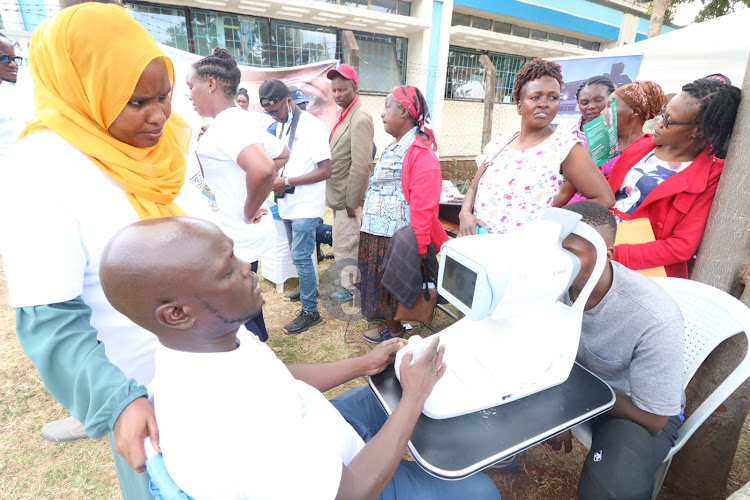 Patients queue in line awaiting eye testing during the marking of the world Glaucoma week on March 14.