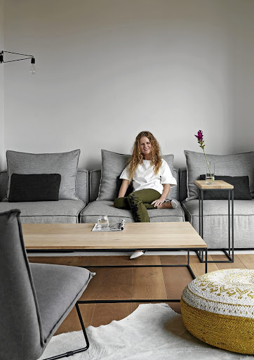 Architect Nadine Engelbrecht sits in the TV room, which creates a comfortable extension of the kitchen.