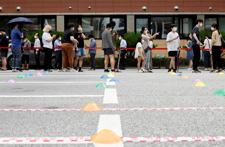 People wait in line for a coronavirus disease (Covid-19) test at a testing site which is temporarily set up at a public health center in Seoul, South Korea, July 9, 2021.