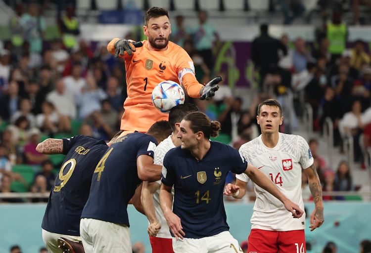 Hugo Lloris (top), goalkeeper of France, makes a save during the Round of 16 match between France and Poland of the 2022 FIFA World Cup at Al Thumama Stadium in Doha, Qatar, Dec. 4, 2022.