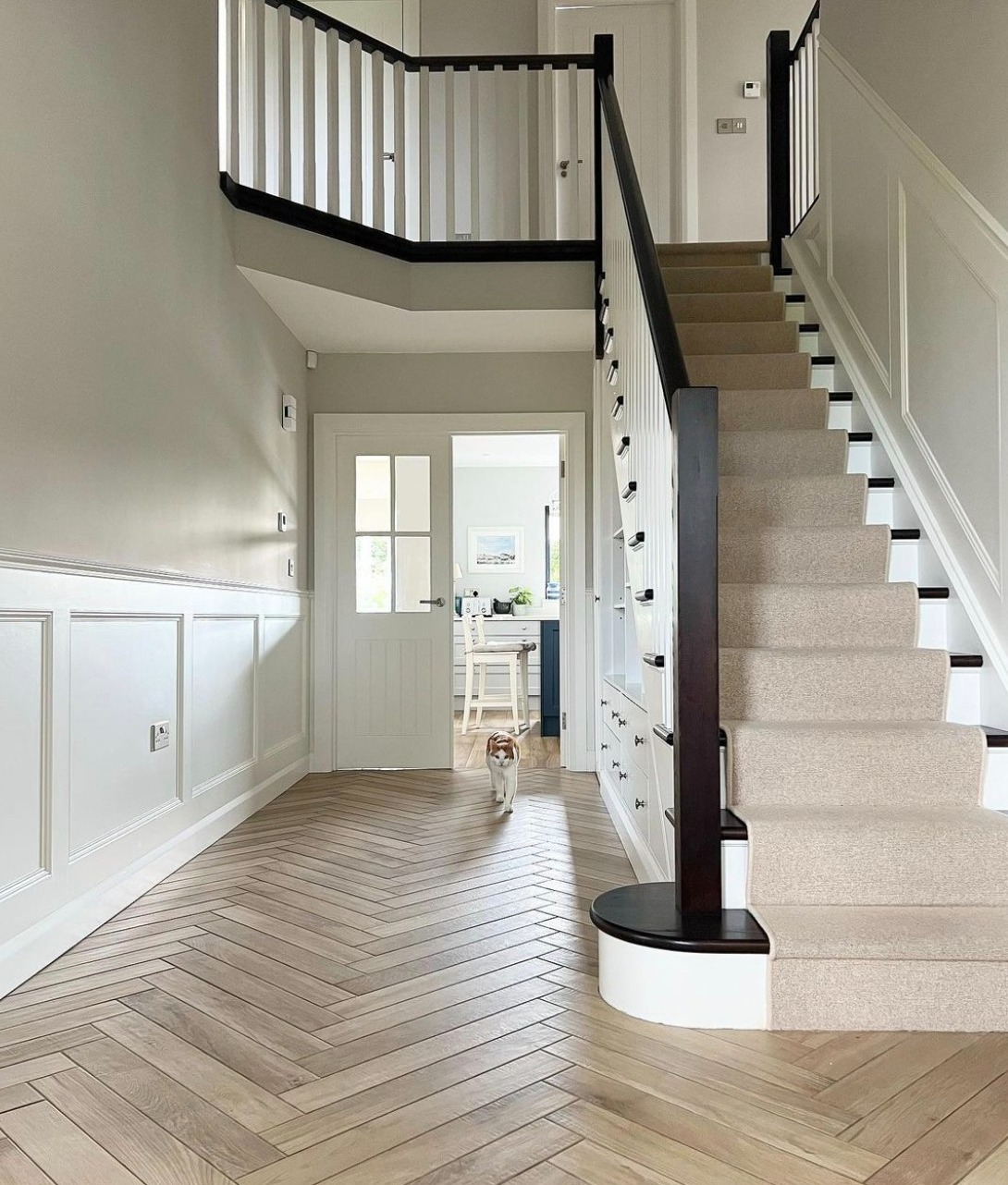 Large spacious hallway with white panelling and Cornforth White walls.