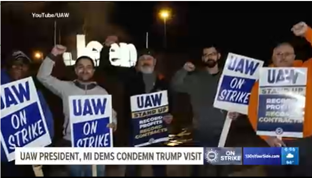 WZZM screenshot of UAW striking workers holding signs saying UAW on Strike