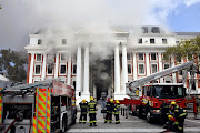 Firefighters work to put out a fire at the parliamentary precinct in Cape Town on January 2 2022.