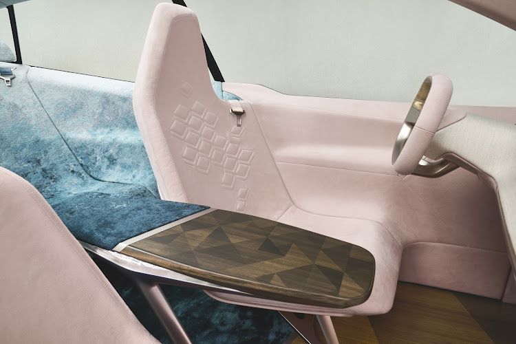 Wooden table helps give the cabin its lounge-like atmosphere, though we're not so sure about the pink upholstery. Picture: SUPPLIED