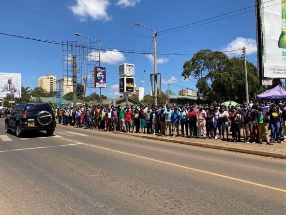 Kenyans line-up on the streets of Eldoret to watch as athletes accompanying the body of the slain Olympian Agnes Tirop