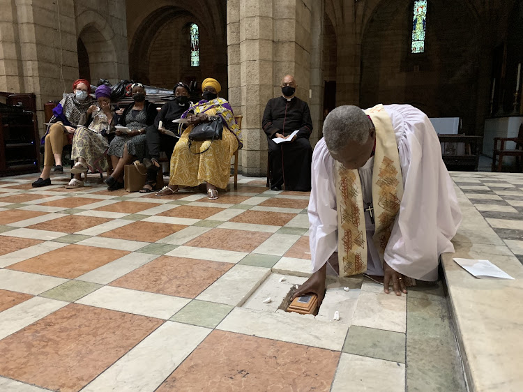 Archbishop Thabo Makgoba lays the ashes of Archbishop Emeritus Desmond Mpilo Tutu to rest at the high altar of St George's Cathedral, with members of the Tutu family and Dean Michael Weeder of the Cathedral in the background