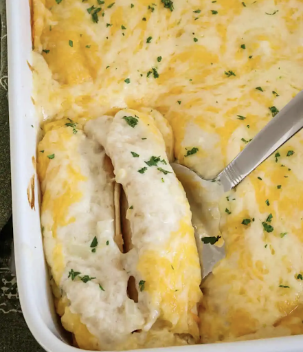 These sour cream chicken enchiladas are cooked chicken mixed with sour cream, Monterey Jack, and cheddar cheese, rolled in tortillas, smothered with sour cream enchilada sauce, and topped with more Monterey Jack and cheddar cheese.
