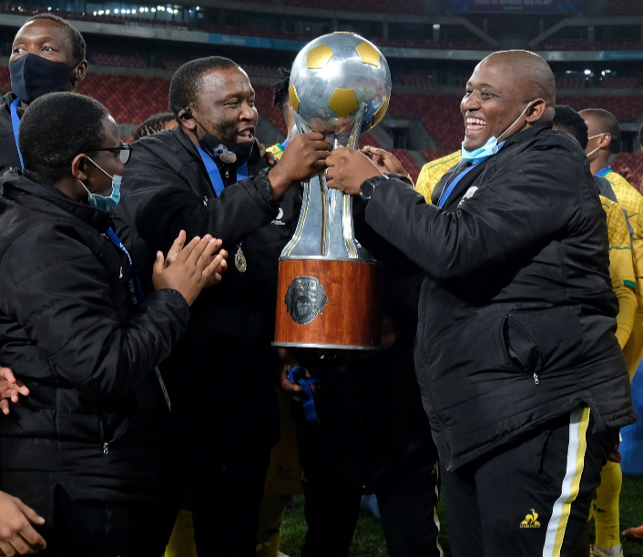 South African head coach Morena Ramoreboli (right) and Sinesipho Mali, assistant coach, (left) celebrate the winning of the Cosafa Cup during the 2021 tournament at Nelson Mandela Bay Stadium on July 18, 2021.