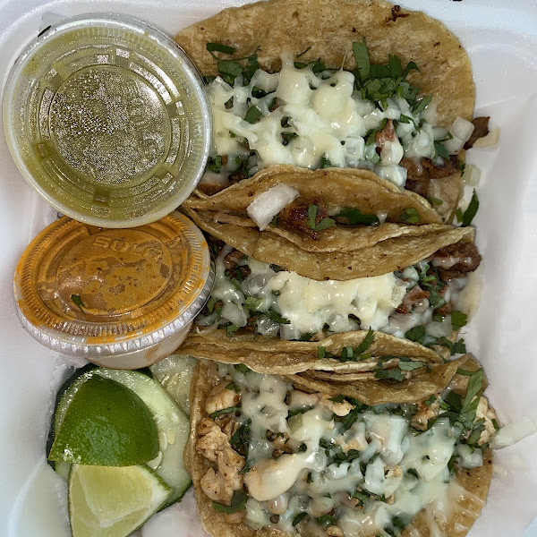 2 al pastor tacos, 1 chicken, topped w cilantro and onion, two side sauces, and limes. I asked for cheese on top.