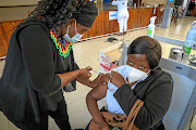 Health worker Thulisile Luthuli is vaccinated at Chris Hani Baragwanath  Hospital in Johannesburg. The government has promised to release a list of vaccine sites on Sunday. 