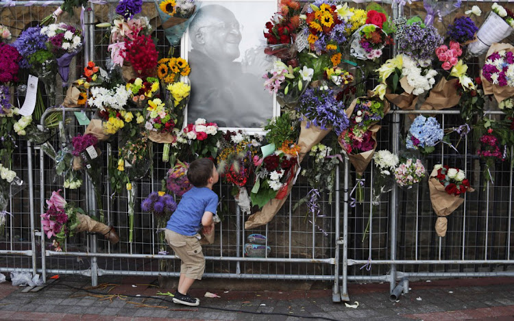 A young boy pays his respects to the late Archbishop Desmond Tutu. The author says white South Africans have yet to grasp the full requirements of ubuntu, the philosophy Tutu spoke about at length.