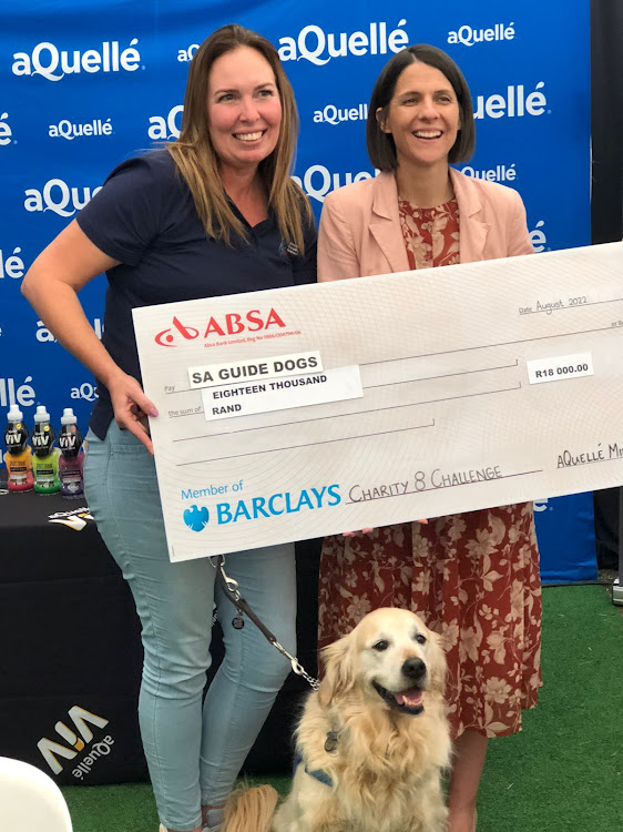 Ané Roux of the SA Guide-Dogs Associations, left and accompanied by Daisy, receives a cheque from Suzelle Stegen of aQuellé, title sponsor of the Midmar Mile, on Saturday.