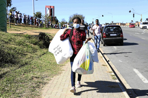 Takalani Makhoba is happy after managing to buy winter clothes for her daughter. Behind her are other residents of Alexandra waiting to get into the Alex Mall.