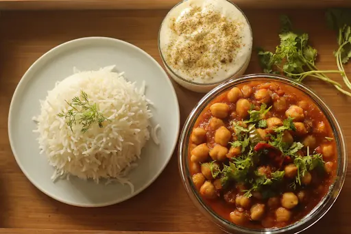 Rice + Chole / Rajma + Raita + Papad + Sweet