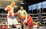 GOING DOWN: National junior-flyweight champion Luzuko Siyo floors Sebelomzi Zimela  at the Orient Theatre in East London recently.Photo: YANDISA MONAKALI