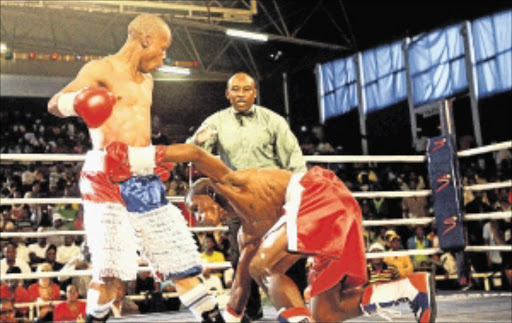 GOING DOWN: National junior-flyweight champion Luzuko Siyo floors Sebelomzi Zimela at the Orient Theatre in East London recently.Photo: YANDISA MONAKALI