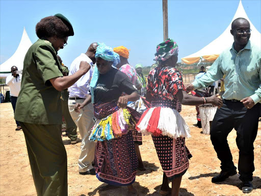 The Kenya Forestry Service (KFS) Board chairman Peter Kinyua (right) joins members of Ihaleni in adance during the signing of the FMA on Monday