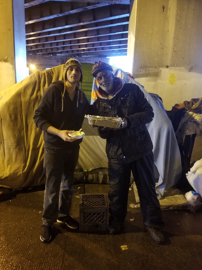 One man helping another man get some food