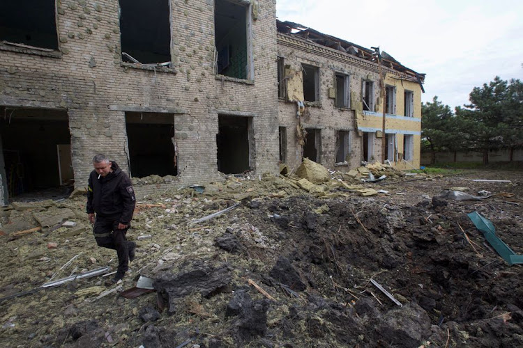 A police officer walks next to a school building damaged by a Russian military strike, as Russia's attack on Ukraine continues, in the settlement of Kostiantynivka, in Donetsk region, Ukraine May 22, 2022. Picture taken May 22, 2022.