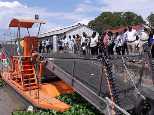 The Parliamentary Committee on Regional Integration and Northern Corridor at the Kisumu port viewing the stalled Sh 80 million water hyacinth harvester.