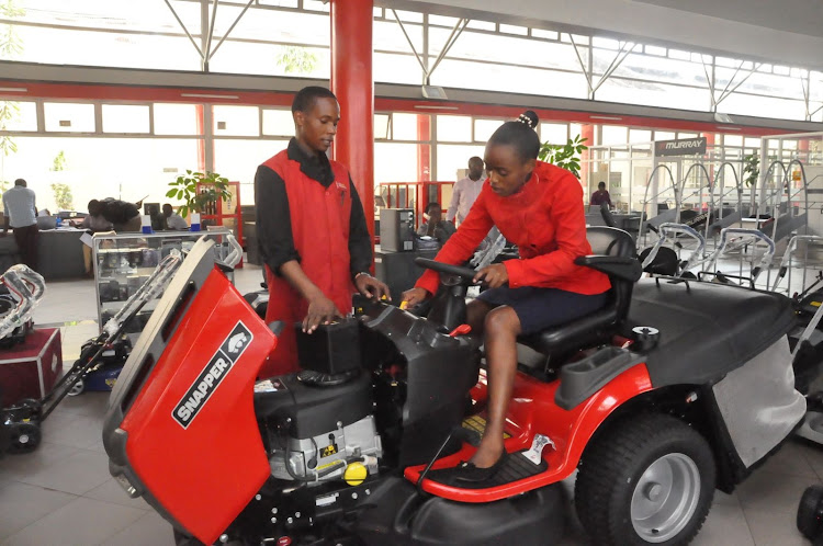 Car and General Briggs and Stratton engines head technician Davis Kuria and sales executive Wendy Wanyama discuss a Snapper ride –on mower. The company stocks ride-on mowers, walk-behind lawn mowers and brush cutters at their showroom on Lusaka Road.