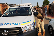 Activist Nhlanhla Lux Dlamini talks to police officers outside his Pimville house in Soweto, Johannesburg. The area was allegedly attacked with a explosives in the early hours of the morning.