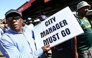 A taxi driver from Ekurhuleni with a board before marching to the office of Mayor Mzwanele Masina demanding for his resignation.
