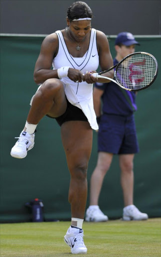 Serena Williams of the U.S. looks at her racquet during her match against Simona Halep of Romania at the Wimbledon tennis championships in London June 23, 2011