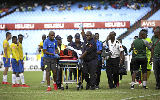 Wandisile Letlabika of Bloemfontein Celtic is stretchered off after being stabilised by the Sundowns medical team led by Dr Carl Tabane, left, following his serious injury at Loftus Versfeld on Saturday.